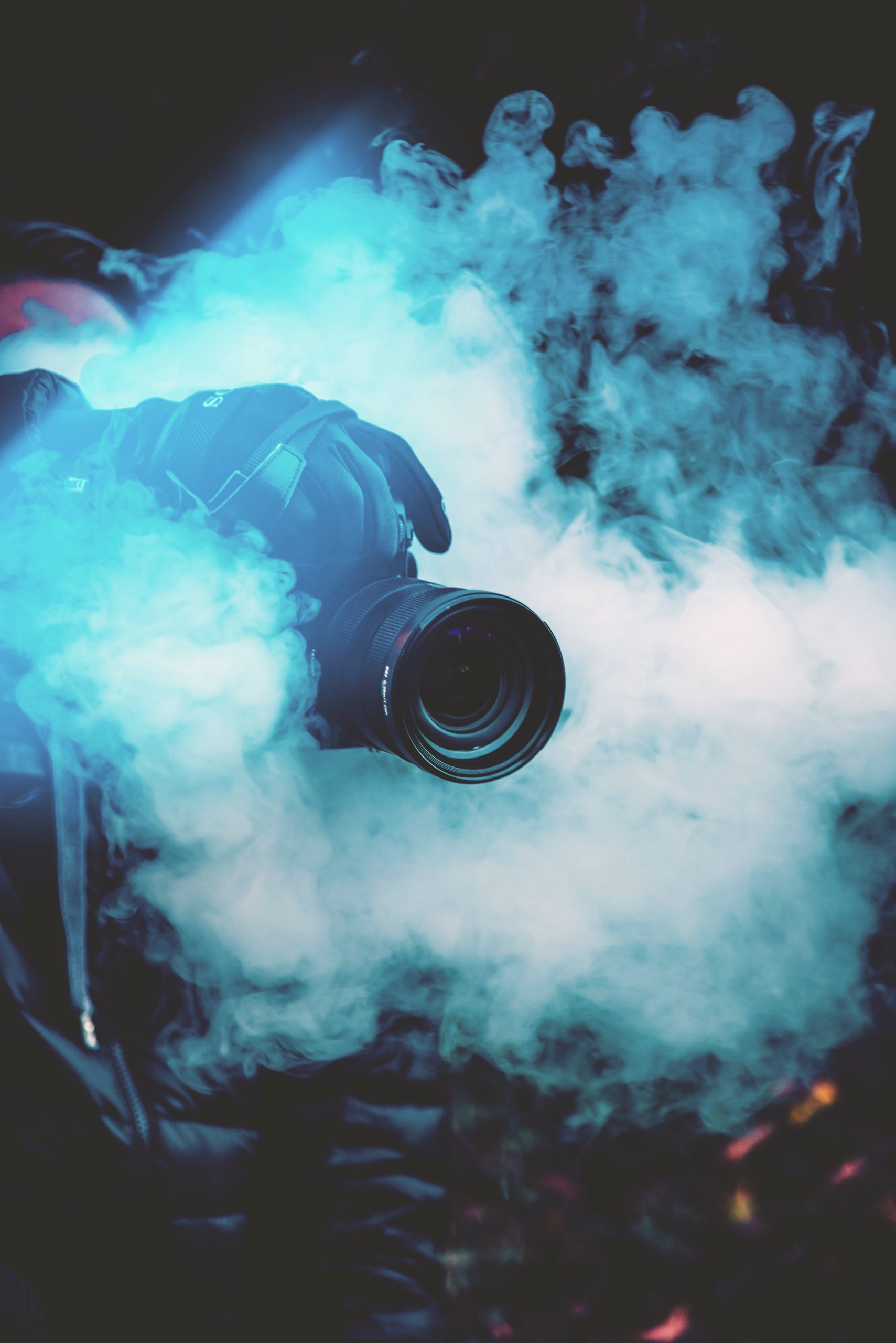 Kameralense som stikker ut av en røyksky med blått lys, reklamefilm